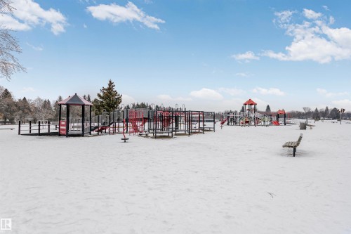 Expansive outdoor recreational area featuring various playground structures on a snow-covered ground - 24 Sable Crescent, St. Albert, AB - Outdoor With View