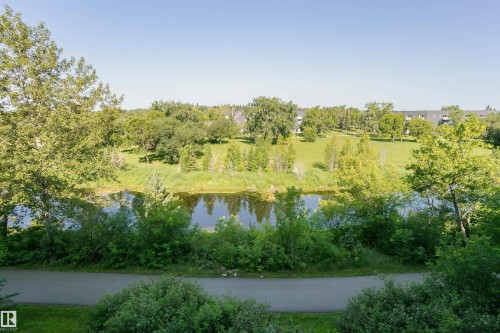 This property offers scenic views of a body of water, surrounded by lush green trees and expansive grassy areas - 24 Sable Crescent, St. Albert, AB - Outdoor With View