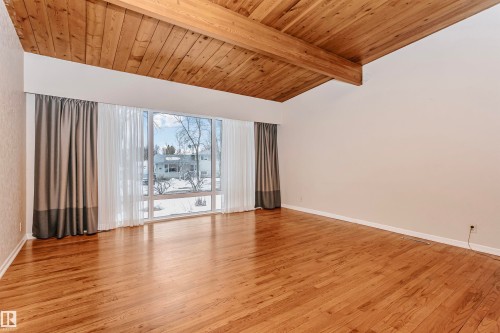 Spacious room featuring a vaulted wooden ceiling with exposed beams, hardwood floors, and large windows providing ample natural light - 24 Sable Crescent, St. Albert, AB - Indoor Photo Showing Other Room