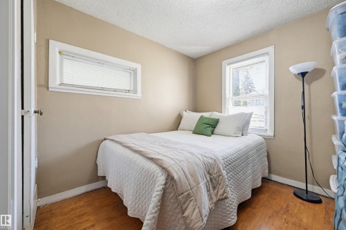 Hardwood-finish flooring complements neutral wall tones - 9816 93 Avenue, Edmonton, AB - Indoor Photo Showing Bedroom