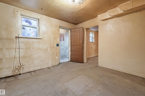 Concrete flooring with a window and two doorways - 9816 93 Avenue, Edmonton, AB - Indoor Photo Showing Other Room