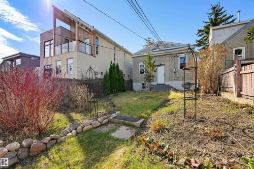 Tiered backyard with a stone retaining wall and mixed plantings - 9816 93 Avenue, Edmonton, AB - Outdoor