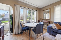 Living area featuring wood-finish flooring, multiple windows providing natural light, and a white ceiling with decorative trim - 