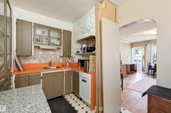 Kitchen featuring painted cabinetry, a stainless steel sink, and a white dishwasher - 