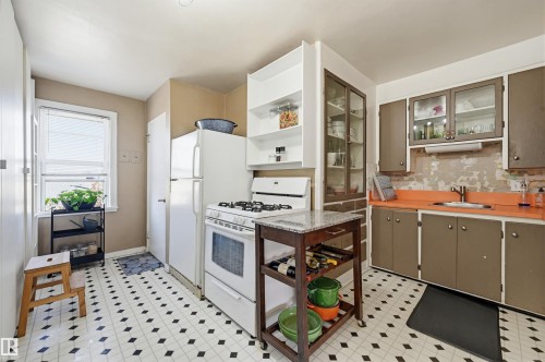 Kitchen featuring white appliances, a light-colored countertop, and a black and white checkered floor - 9816 93 Avenue, Edmonton, AB - Indoor Photo Showing Kitchen