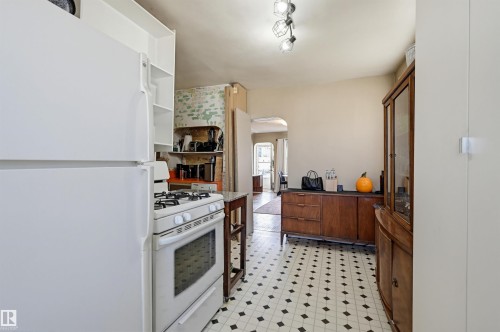 Kitchen featuring white appliances, a gas range, white open shelving, black and white checkered flooring, and a track light fixture - 9816 93 Avenue, Edmonton, AB - Indoor Photo Showing Other Room