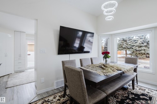 Dining area featuring a bay window, a contemporary chandelier, and light wood-finish flooring - 236 Lago Lindo Crescent, Edmonton, AB - Indoor Photo Showing Dining Room