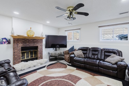 Living area featuring a brick-surround fireplace with a wood mantle, recessed lighting, and a ceiling fan - 236 Lago Lindo Crescent, Edmonton, AB - Indoor Photo Showing Living Room With Fireplace