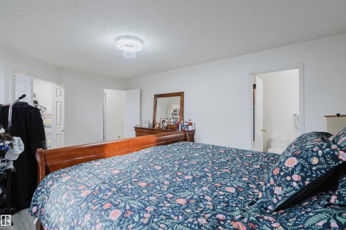 Bedroom featuring neutral wall paint, wood-finish flooring, and a decorative flush-mount ceiling light fixture - 236 Lago Lindo Crescent, Edmonton, AB - Indoor Photo Showing Bedroom