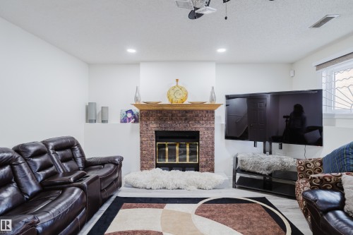 Living area featuring a brick fireplace with a wood mantle, recessed lighting, and light-toned flooring - 236 Lago Lindo Crescent, Edmonton, AB - Indoor With Fireplace