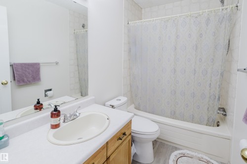 Bathroom featuring a vanity with integrated sink, wood-finish cabinetry, and a full-width mirror - 236 Lago Lindo Crescent, Edmonton, AB - Indoor Photo Showing Bathroom