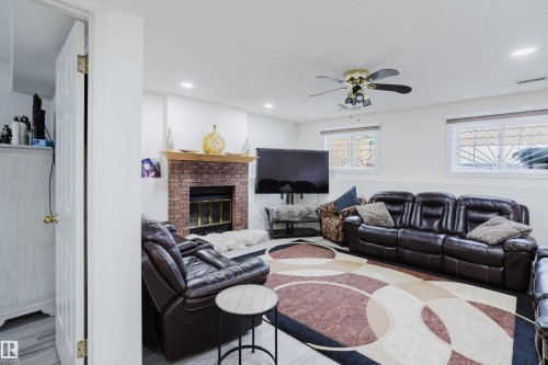 Living area featuring a brick-front fireplace with a wood mantel, recessed lighting, and a ceiling fan - 236 Lago Lindo Crescent, Edmonton, AB - Indoor Photo Showing Living Room With Fireplace