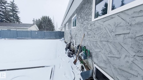 Exterior wall featuring textured stucco finish and multiple windows with white frames - 3311 108 Street, Edmonton, AB - Outdoor