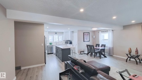 Open-concept living space featuring wood-finish flooring, recessed lighting, and neutral wall tones - 3311 108 Street, Edmonton, AB - Indoor