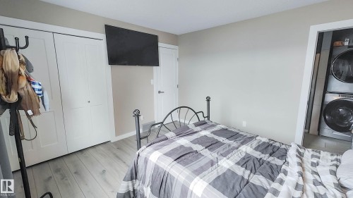 Light wood-finish flooring with white trim and neutral wall paint - 3311 108 Street, Edmonton, AB - Indoor Photo Showing Laundry Room