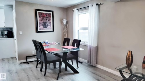 Dining area featuring wood-finish flooring and a window with sheer curtains - 3311 108 Street, Edmonton, AB - Indoor Photo Showing Dining Room