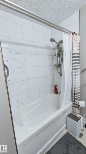 Bathtub with a white surround and white subway tile shower walls - 3311 108 Street, Edmonton, AB - Indoor Photo Showing Bathroom