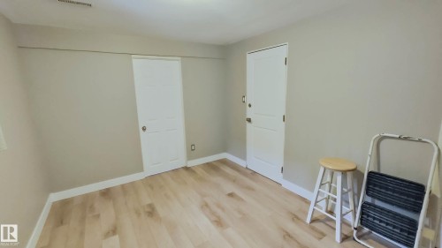 Neutral-toned room featuring light wood-finish flooring and white baseboards - 3311 108 Street, Edmonton, AB - Indoor Photo Showing Other Room