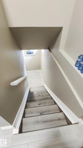 Staircase featuring wood-finish treads and risers with white trim - 3311 108 Street, Edmonton, AB - Indoor Photo Showing Other Room