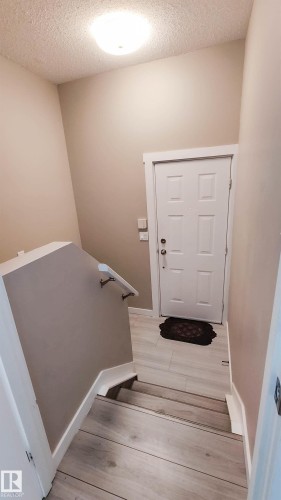 Entryway featuring light wood-finish flooring, a white paneled door, and a flush-mount ceiling light fixture - 3311 108 Street, Edmonton, AB - Indoor Photo Showing Other Room