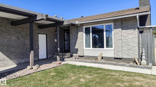 Mid-century modern facade featuring textured stucco, a covered entry, and a large multi-pane window - 3311 108 Street, Edmonton, AB - Outdoor