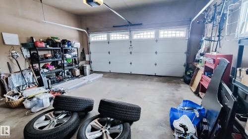 Attached garage with a white sectional door featuring decorative windows - 3311 108 Street, Edmonton, AB - Indoor Photo Showing Garage