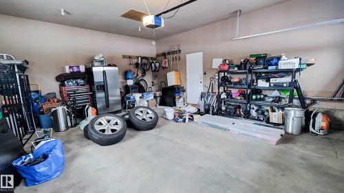 Attached two-car garage featuring a concrete floor, neutral wall paint, and overhead lighting - 3311 108 Street, Edmonton, AB - Indoor Photo Showing Garage
