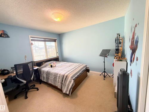 Carpeted room featuring a double window with blinds, light blue walls, and a ceiling-mounted light fixture - 3538 Claxton Crescent, Edmonton, AB - Indoor Photo Showing Bedroom