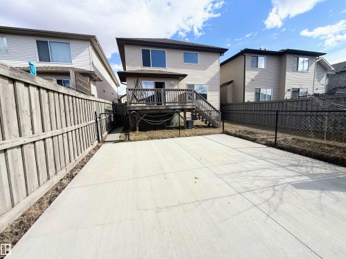 Rear exterior featuring a raised wooden deck with stairs, vinyl siding, and a concrete patio - 3538 Claxton Crescent, Edmonton, AB - Outdoor With Exterior