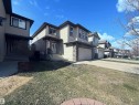 Two-story residence featuring light-colored siding, a stone facade, and a two-car garage - 3538 Claxton Crescent, Edmonton, AB  - Outdoor 