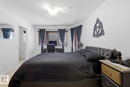 Bedroom featuring a window with horizontal blinds, overhead lighting, and wall-to-wall carpeting - 304 4312 139 Ave, Edmonton, AB - Indoor Photo Showing Bedroom