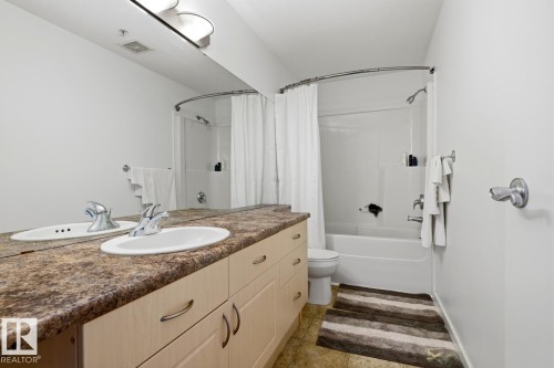 Bathroom featuring a double vanity with two oval sinks and a patterned countertop - 304 4312 139 Ave, Edmonton, AB - Indoor Photo Showing Bathroom