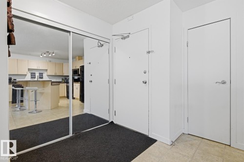 Mirrored closet doors offering a reflection of the kitchen area - 304 4312 139 Ave, Edmonton, AB - Indoor Photo Showing Other Room