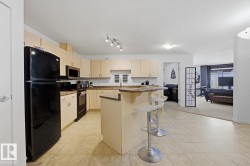 Kitchen featuring wood-finish cabinetry, dark countertops, and tile flooring - 