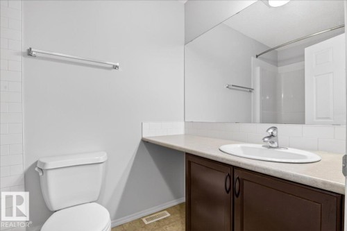 Bathroom featuring a single vanity with a countertop, an undermount sink, and a large mirror - #7 18004 89 St Nw, Edmonton, AB - Indoor Photo Showing Bathroom