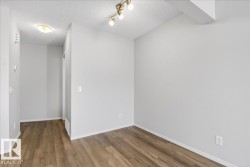Open-concept interior featuring wood-finish flooring, light gray wall paint, and white baseboards - 