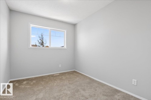 Light gray painted walls with white trim and neutral carpeting - #7 18004 89 St Nw, Edmonton, AB - Indoor Photo Showing Other Room