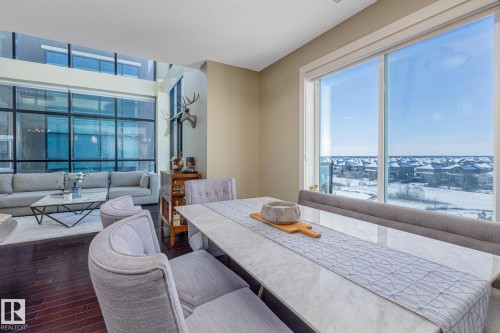 Open-concept living space with dark wood-finish flooring - 513 1230 Windermere Way, Edmonton, AB 