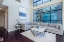 Two-story living area featuring dark wood-finish flooring, a wall of floor-to-ceiling windows, and a high ceiling - 513 1230 Windermere Way, Edmonton, AB 