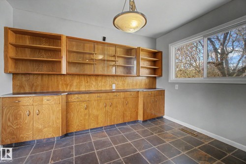 Built-in wood cabinetry with glass-front uppers, ample storage, and a dark countertop - 6048 105B Street, Edmonton, AB - Indoor Photo Showing Other Room