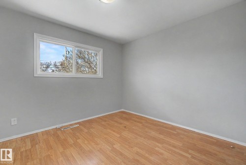 Interior room featuring wood-finish flooring, light gray walls, and white trim - 6048 105B Street, Edmonton, AB - Indoor Photo Showing Other Room