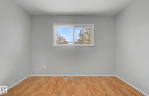 Room featuring wood-finish flooring, light grey painted walls, and a white-framed window - 6048 105B Street, Edmonton, AB - Indoor Photo Showing Other Room