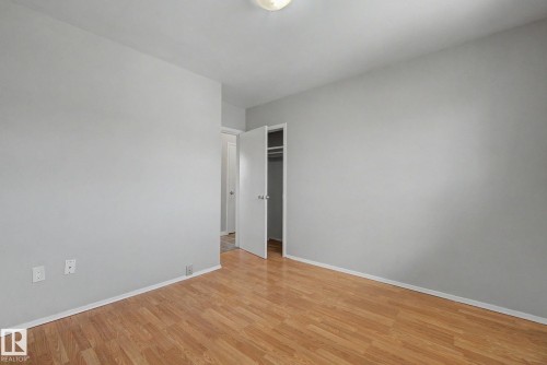 Room featuring light gray walls, wood-finish flooring, white baseboards, and a flush mount ceiling light - 6048 105B Street, Edmonton, AB - Indoor Photo Showing Other Room