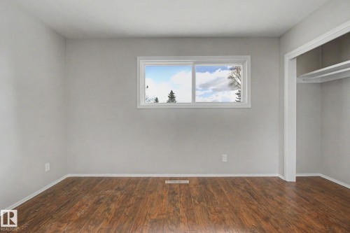 Windowed room featuring wood-finish flooring, light gray wall paint, white baseboards, and a white-trimmed window - 6048 105B Street, Edmonton, AB - Indoor Photo Showing Other Room