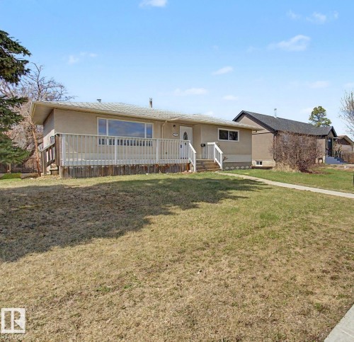 Single-story residence featuring a front deck with white railings, an accessible front entrance, and a light-colored exterior finish - 6048 105B Street, Edmonton, AB - Outdoor