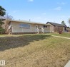 Single-story residence featuring a front deck with white railings, an accessible front entrance, and a light-colored exterior finish - 6048 105B Street, Edmonton, AB  - Outdoor 