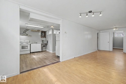 Open concept living area featuring wood-finish flooring and track lighting - 6048 105B Street, Edmonton, AB - Indoor