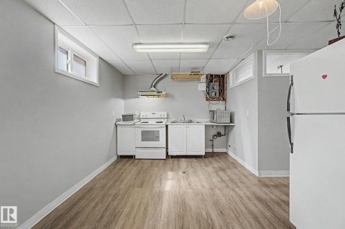 Open-concept room featuring wood-finish flooring, light grey walls, and a white drop ceiling - 6048 105B Street, Edmonton, AB - Indoor