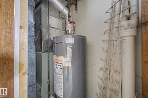 Central water heater unit with associated plumbing and ductwork - 6048 105B Street, Edmonton, AB - Indoor Photo Showing Basement
