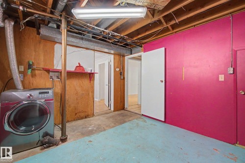 Basement utility area featuring exposed joist ceiling, concrete flooring, and multiple doorways - 6048 105B Street, Edmonton, AB - Indoor Photo Showing Laundry Room